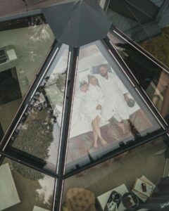 A couple laying in bed inside the glass igloo