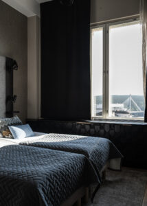 Hotellihuoneen sängyt ja ikkunasta näkyy Jätkänkynttilän silta