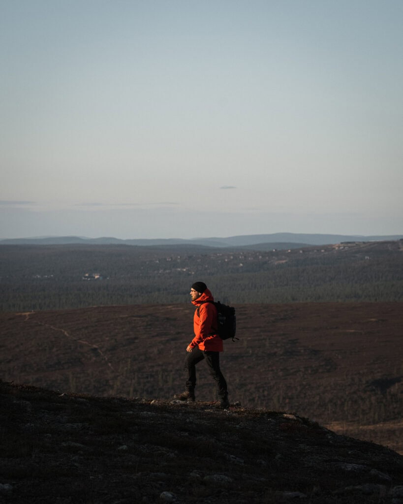 Person hiking in mountains with backpack, scenic landscape, outdoor adventure.