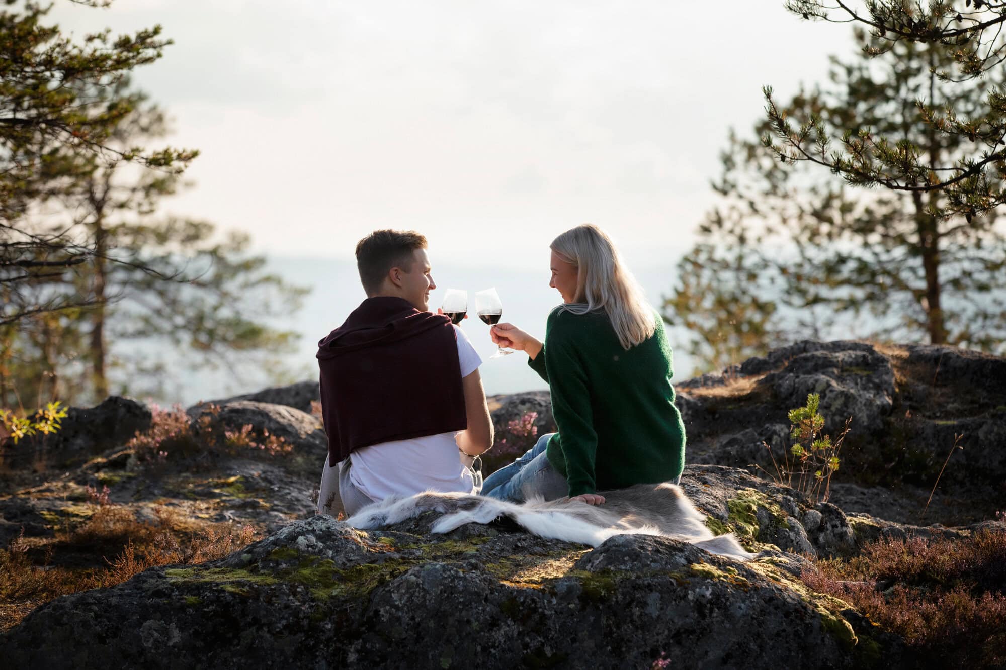 A couple having a glass of wine in Juhannuskallio, Rovaniemi