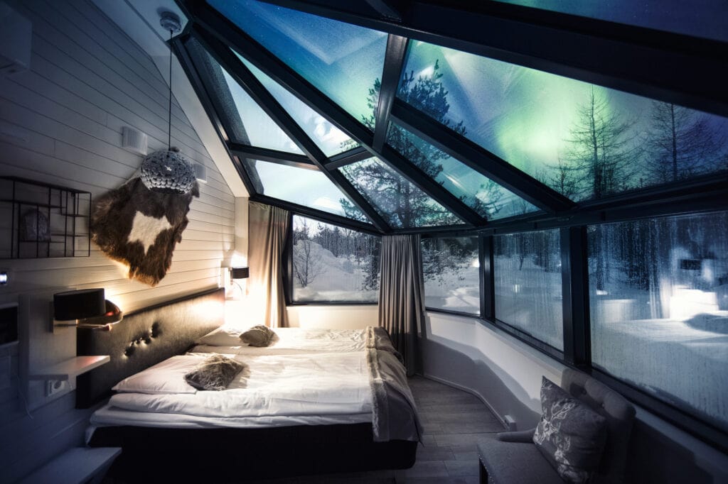 Glass igloo inside with northern lights outside