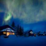 Northern lights above the glass igloos in winter