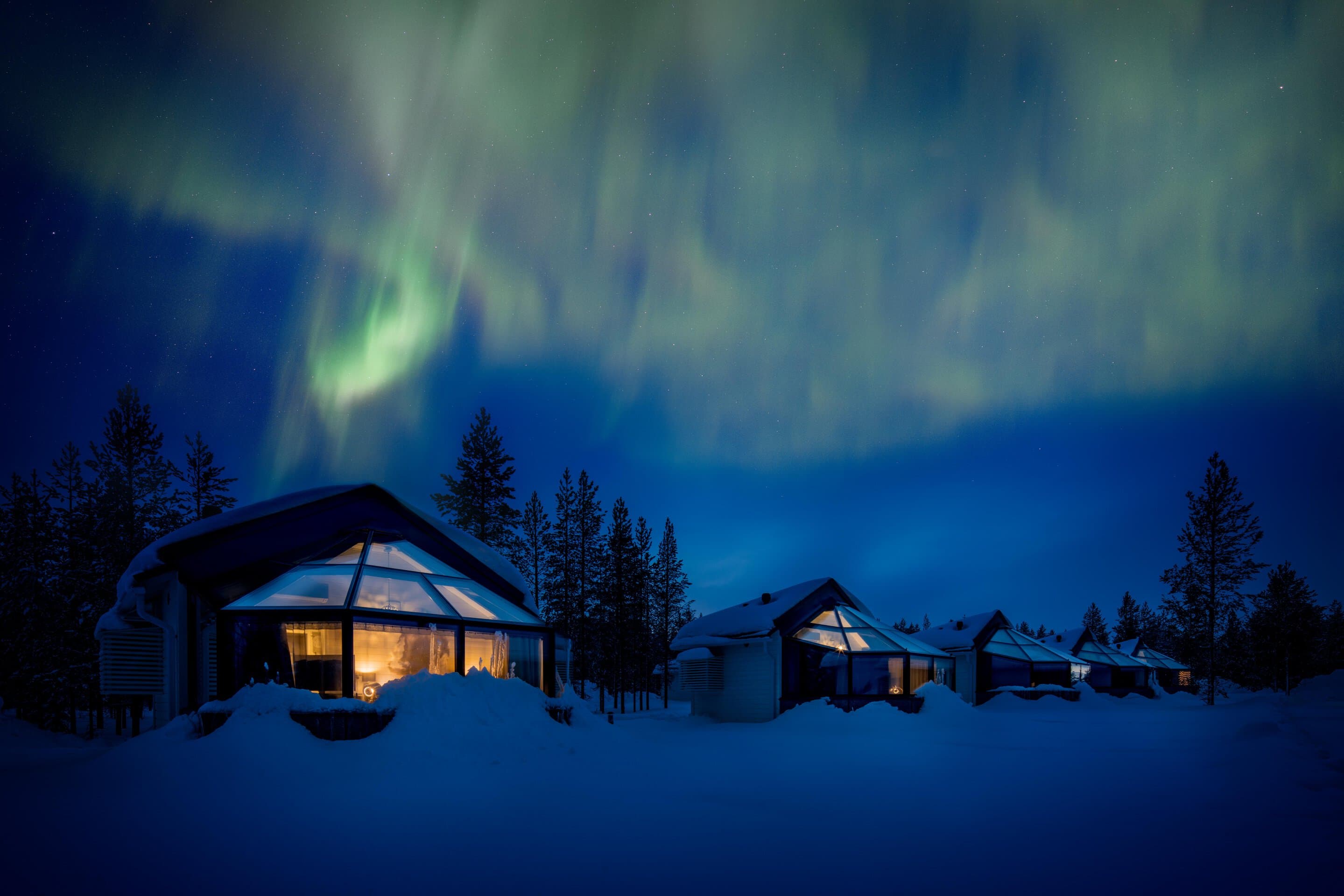 Northern lights above the glass igloos in winter