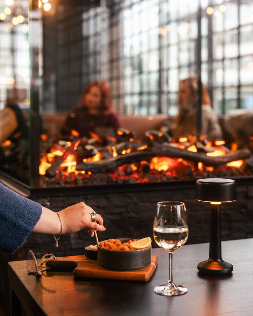 Takkatuli, viinilasi ja bar snacks-listan katkarapuannos