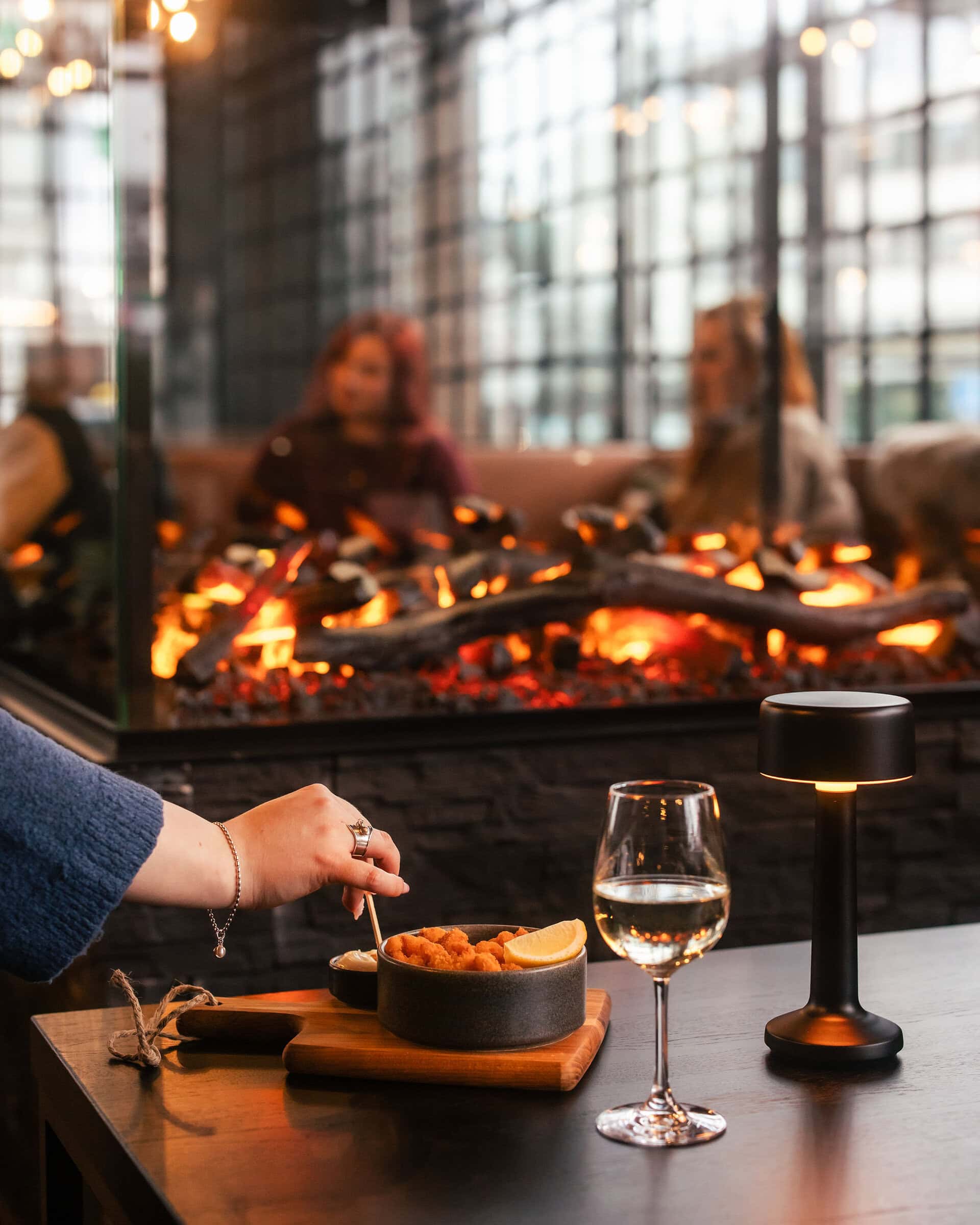 Fireplace, glass of wine and Fried shrimp dish from the bar snacks menu
