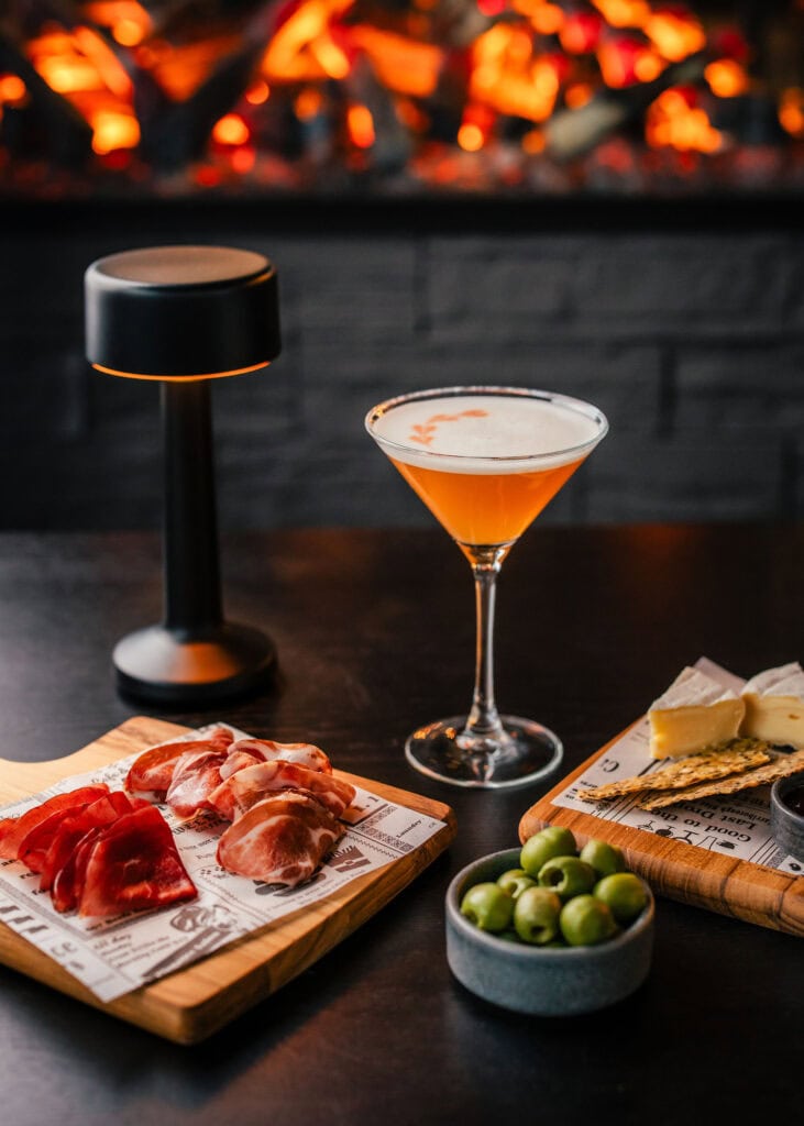Cold cuts, olives and a drink on the table