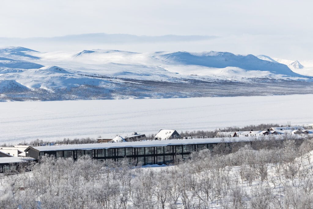 Aerial photo of the hotel, lake covered in ice and snowy fells