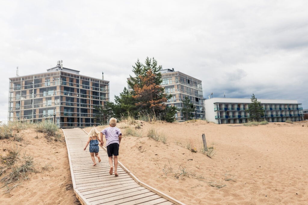 Kids running towards the hotel from the sand dunes
