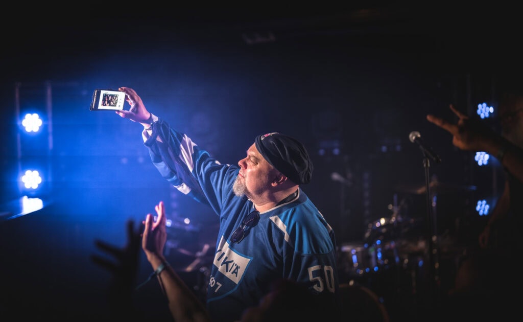Artisti ottamassa selfietä lavalla yleisön kanssa