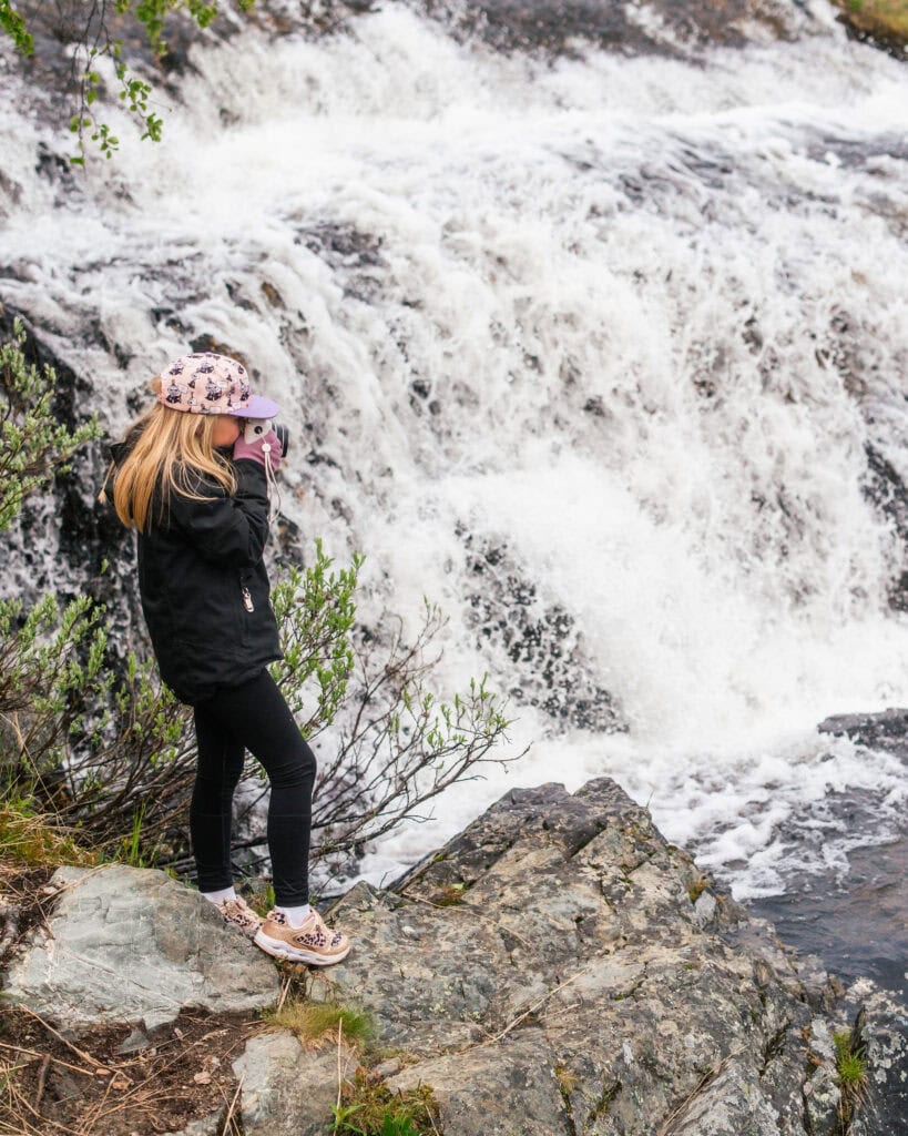 A girl standing in front of a waterfall