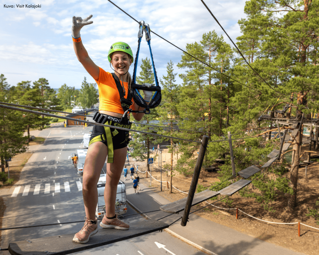 Tyttö kiipeilemässä seikkailupuiston radalla