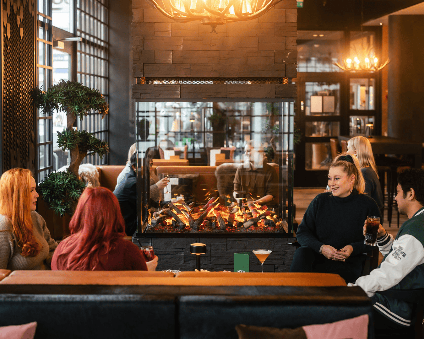 Asiakkaita Nook Loungessa takkatulen ääressä
